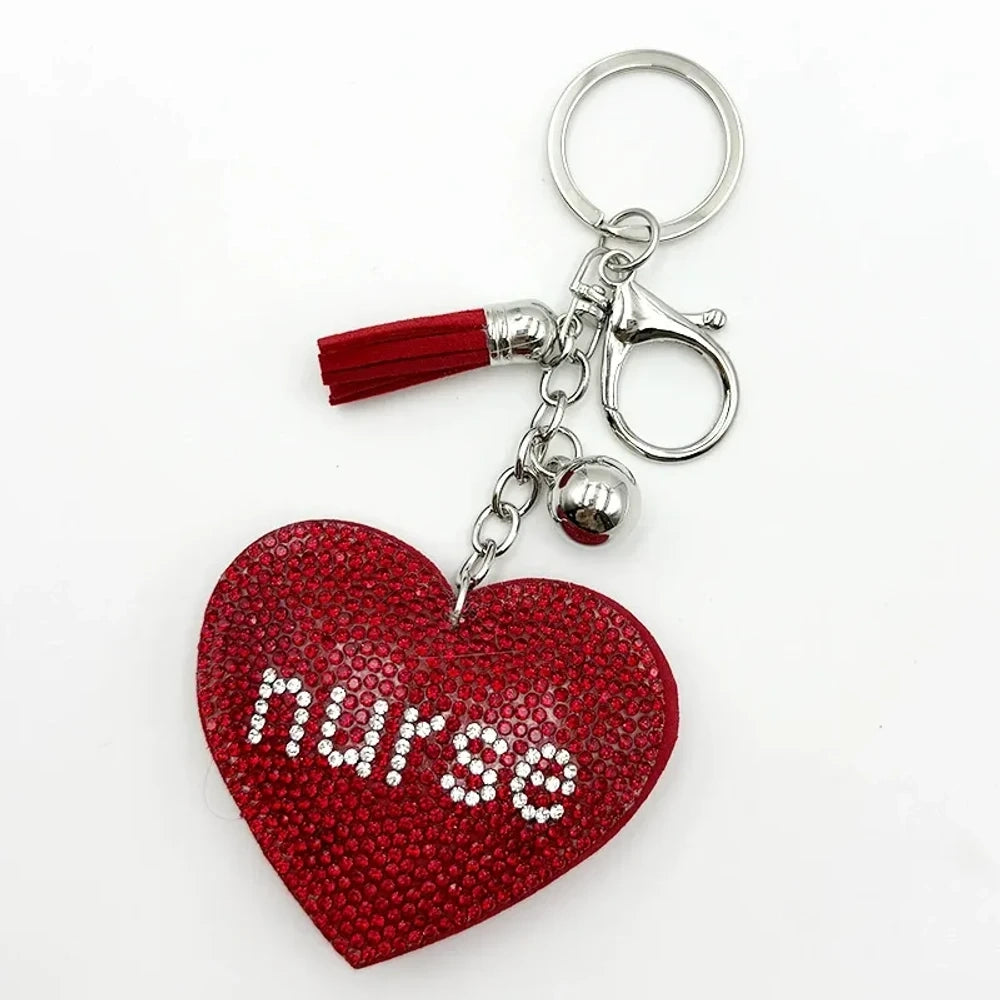Black rhinestone heart-shaped nurse keychain charm with silver tassel, bell, and lobster clasp on white background - Red