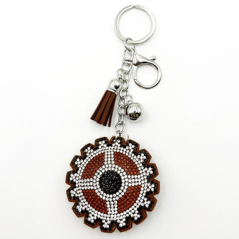 Brown evil eye rhinestone beaded keychain charm with silver tassel, bell, and lobster clasp on white background