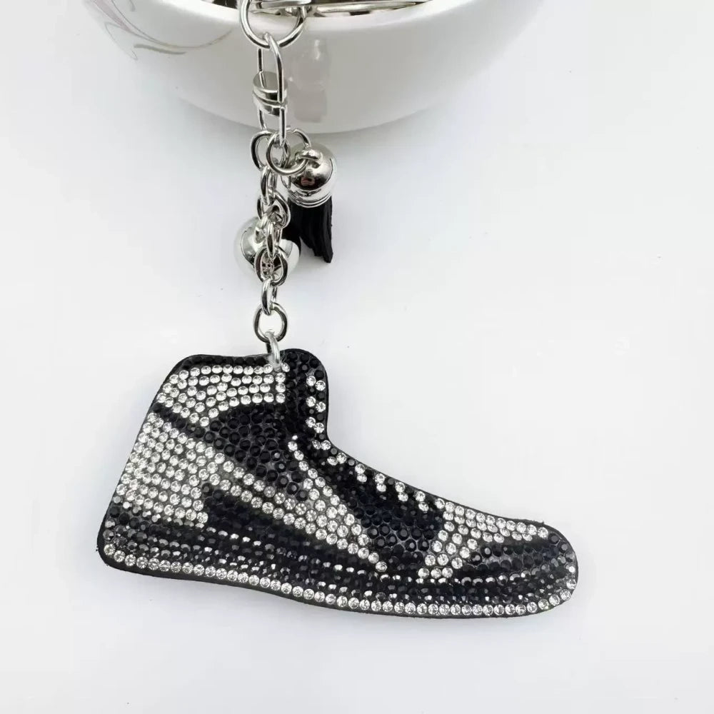 Four assorted rhinestone high-top sneaker fancy beads in black, blue, red, and pink keychain style charms on a white background - White