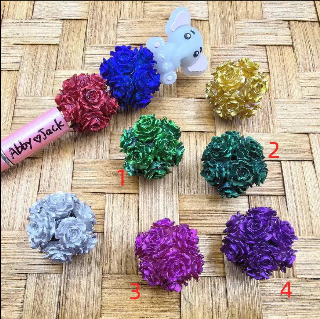 Metallic rose flower ball fancy beads in 7 colors including blue, red, gold, green, dark green, silver, magenta, and purple arranged on woven surface for DIY crafts.