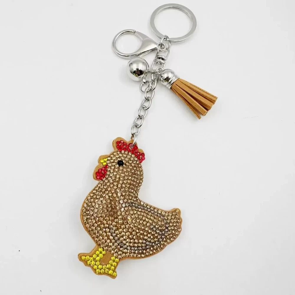 Two white hen rhinestone fancy bead charms with silver keychain rings and tassel accents on white background - Khaki