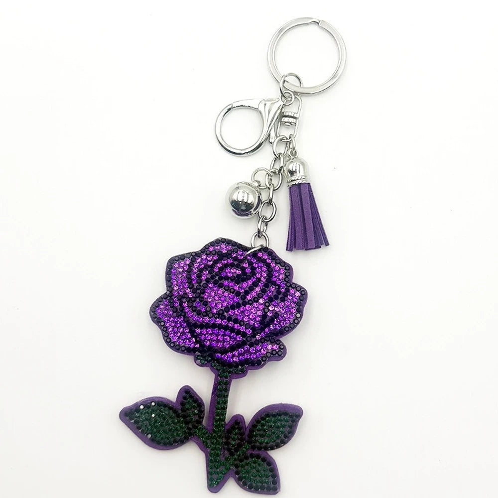 Sparkling red and black rhinestone rose flower keychain charm with gold ring, lobster clasp, gold bead, and red tassel accent on white background. - Purple
