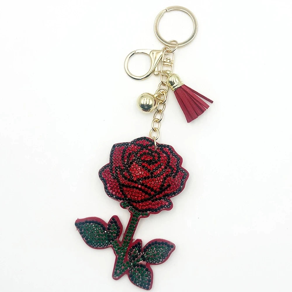 Sparkling red and black rhinestone rose flower keychain charm with gold ring, lobster clasp, gold bead, and red tassel accent on white background. - Random Mixed