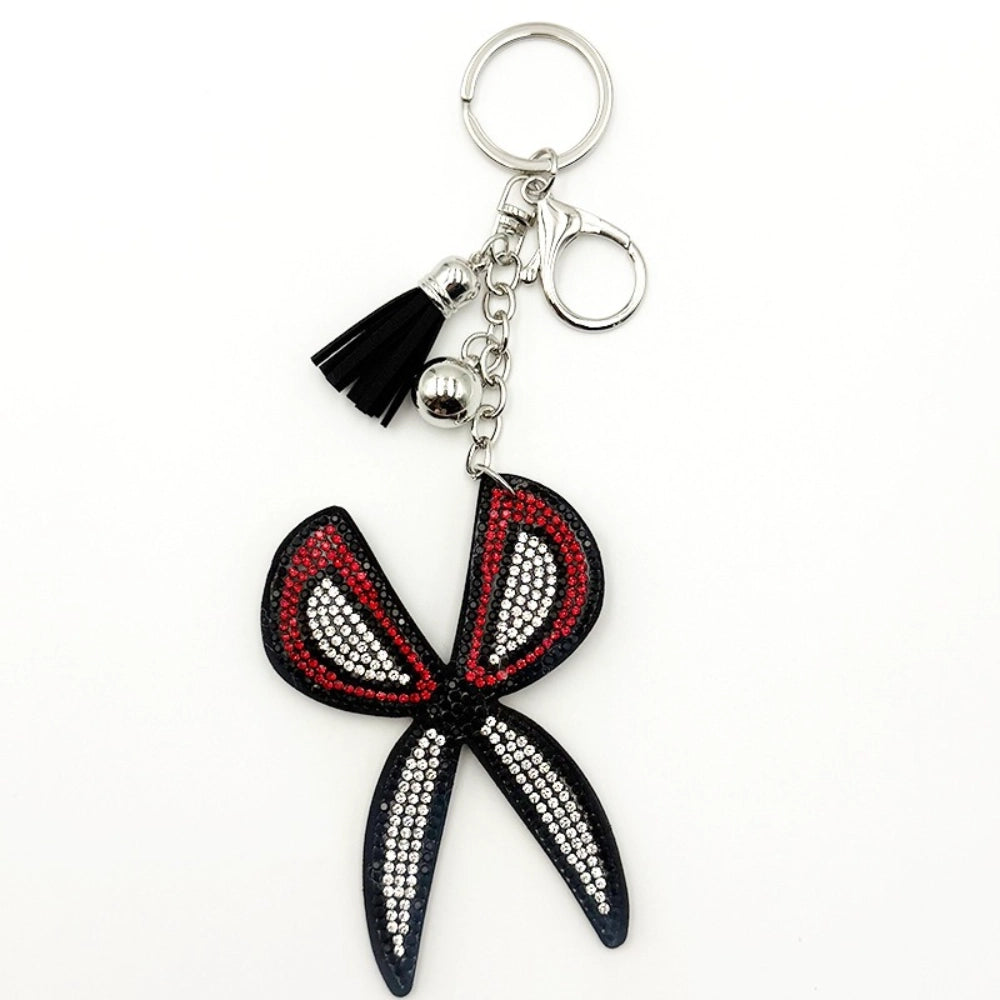 Black red and white rhinestone butterfly bow keychain charm with silver tassel and lobster clasp on white background