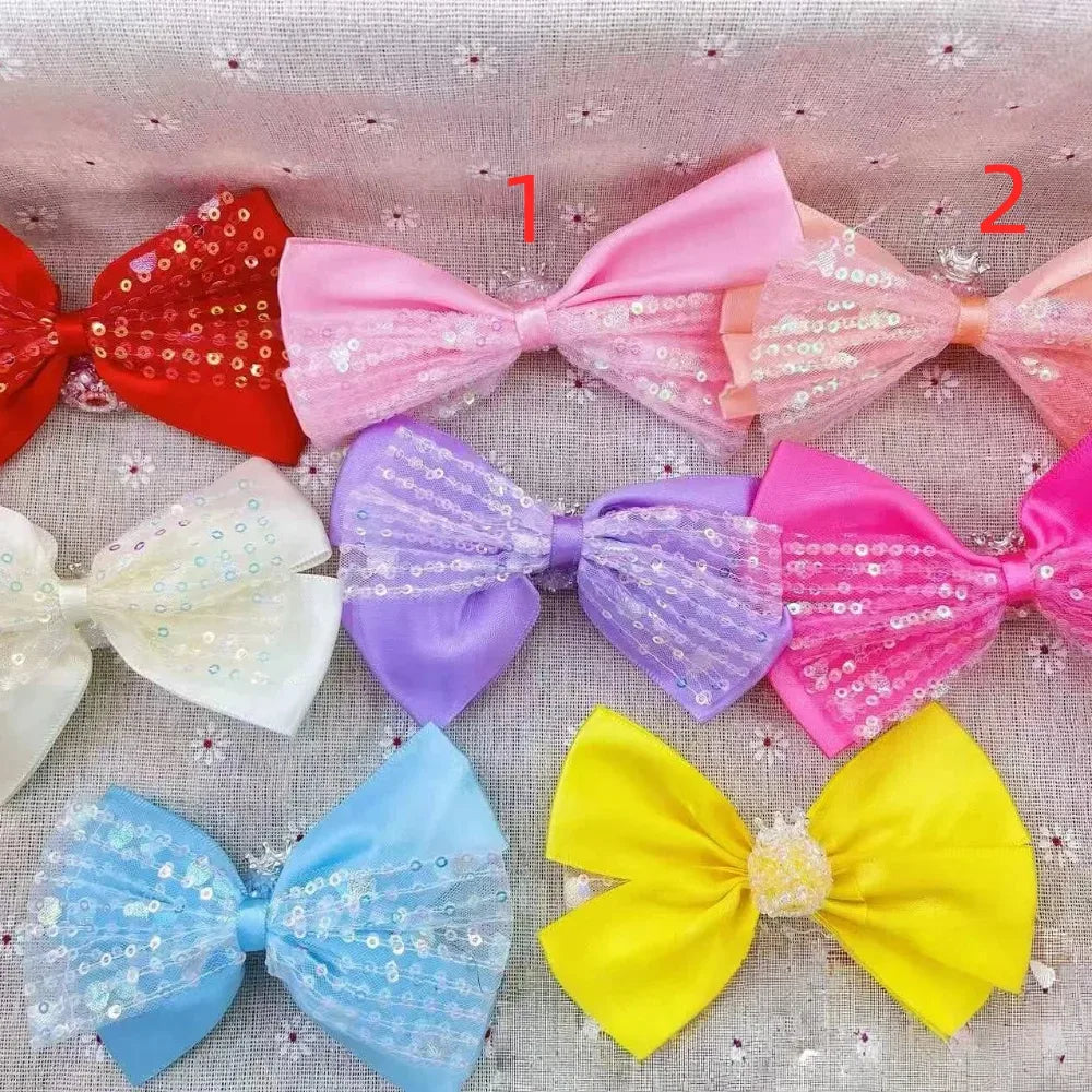 Eight colorful sequin lace and satin ribbon bows in red, pink, white, lavender, hot pink, light blue, yellow, and peach arranged on a floral background for DIY crafts and hair accessories.