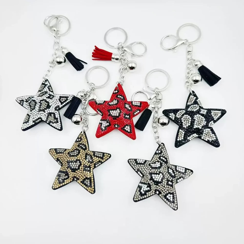 Five star-shaped leopard print rhinestone resin fancy beads in black, red, gold, and silver tones displayed as keychain-style craft pieces.