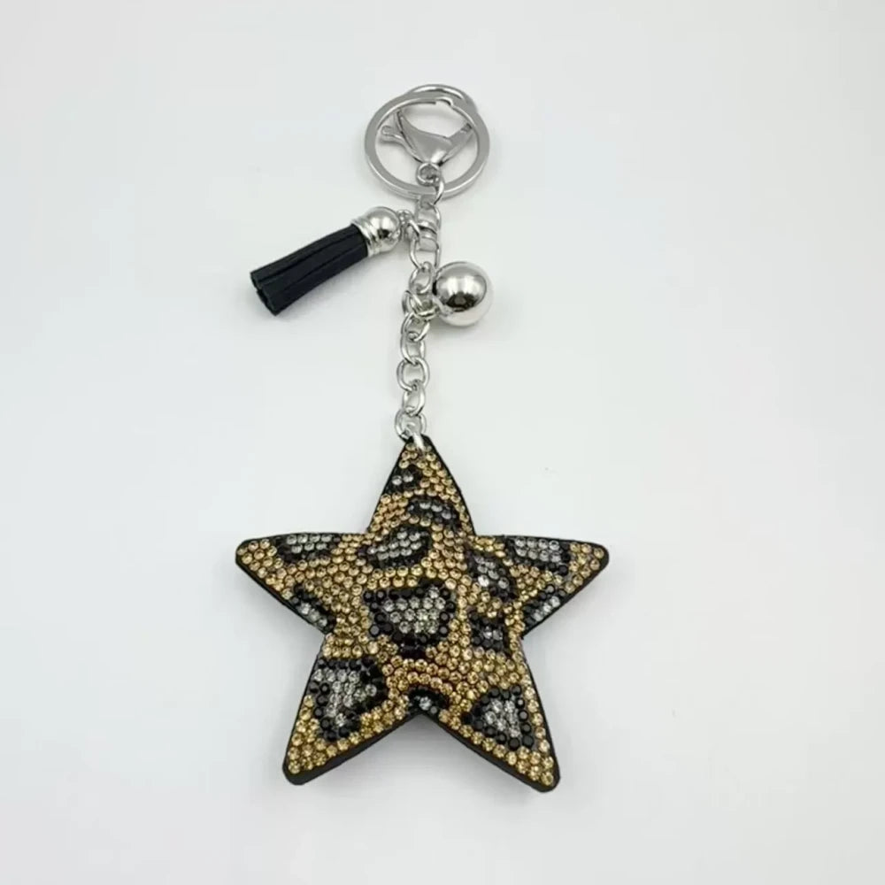 Five star-shaped leopard print rhinestone resin fancy beads in black, red, gold, and silver tones displayed as keychain-style craft pieces. - khaki