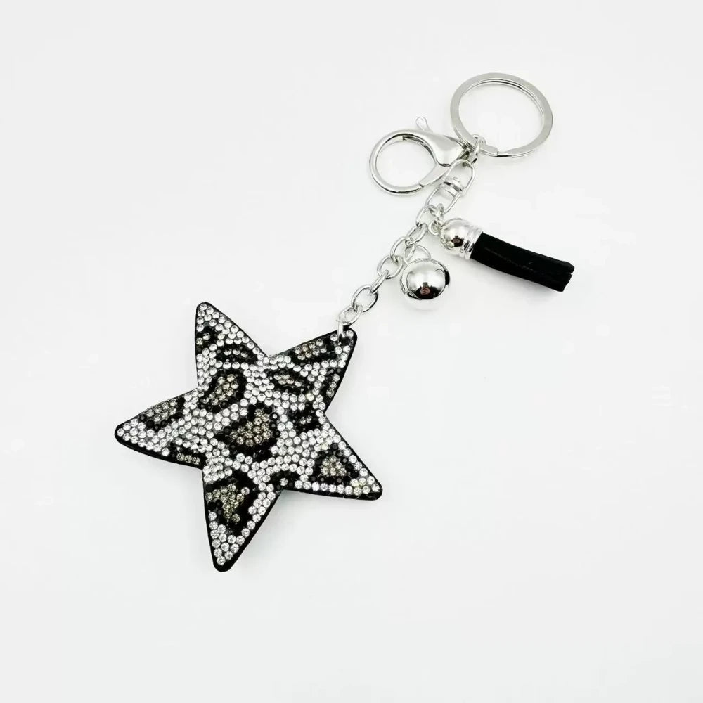 Five star-shaped leopard print rhinestone resin fancy beads in black, red, gold, and silver tones displayed as keychain-style craft pieces. - White