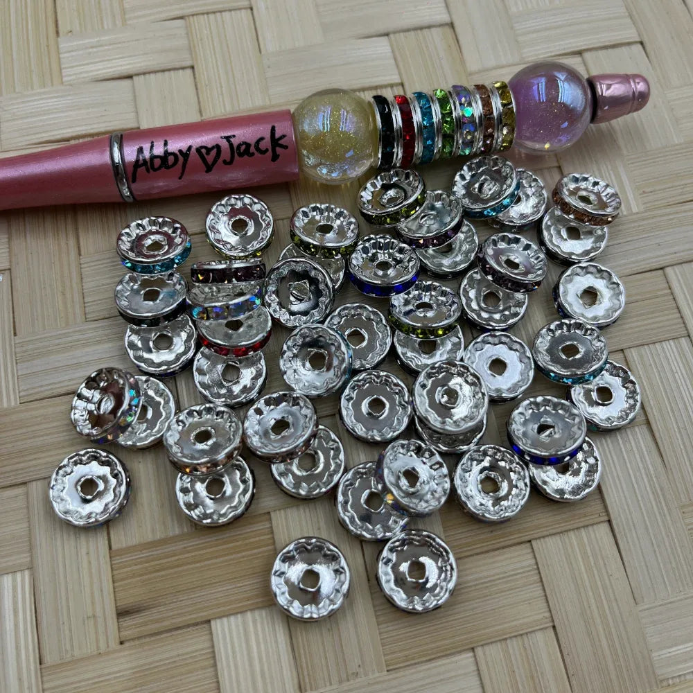 12MM silver rhinestone rondelle metal spacers with assorted crystal bands shown beside a decorated beadable pen