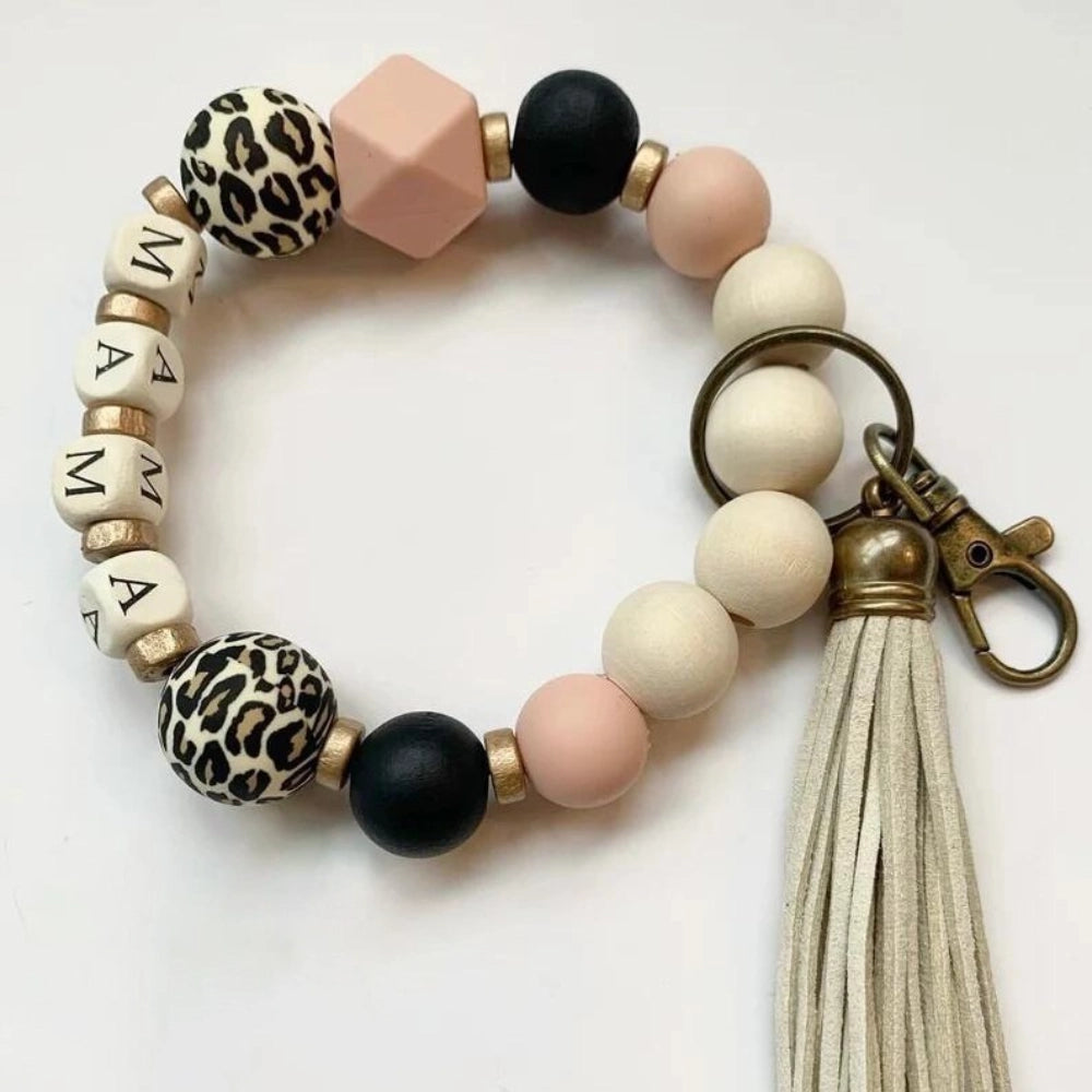15mm leopard print silicone bead shown on a beaded wristlet keychain alongside black, blush pink, and natural wood beads with a tassel charm. - 1