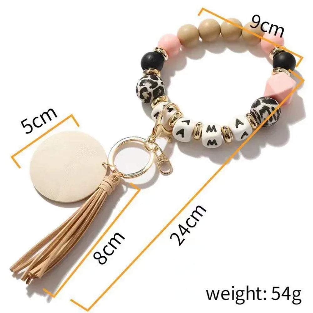 15mm leopard print silicone bead shown on a beaded wristlet keychain alongside black, blush pink, and natural wood beads with a tassel charm. - 2