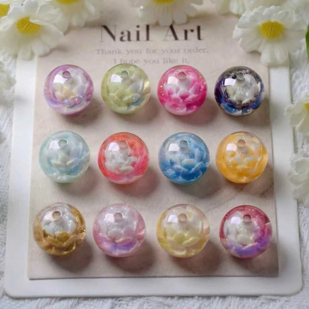 12-piece set of 16MM round acrylic beads featuring floral galaxy glitter designs in assorted pastel and vibrant colors including pink, blue, yellow, purple, and green, displayed on a nail art card.