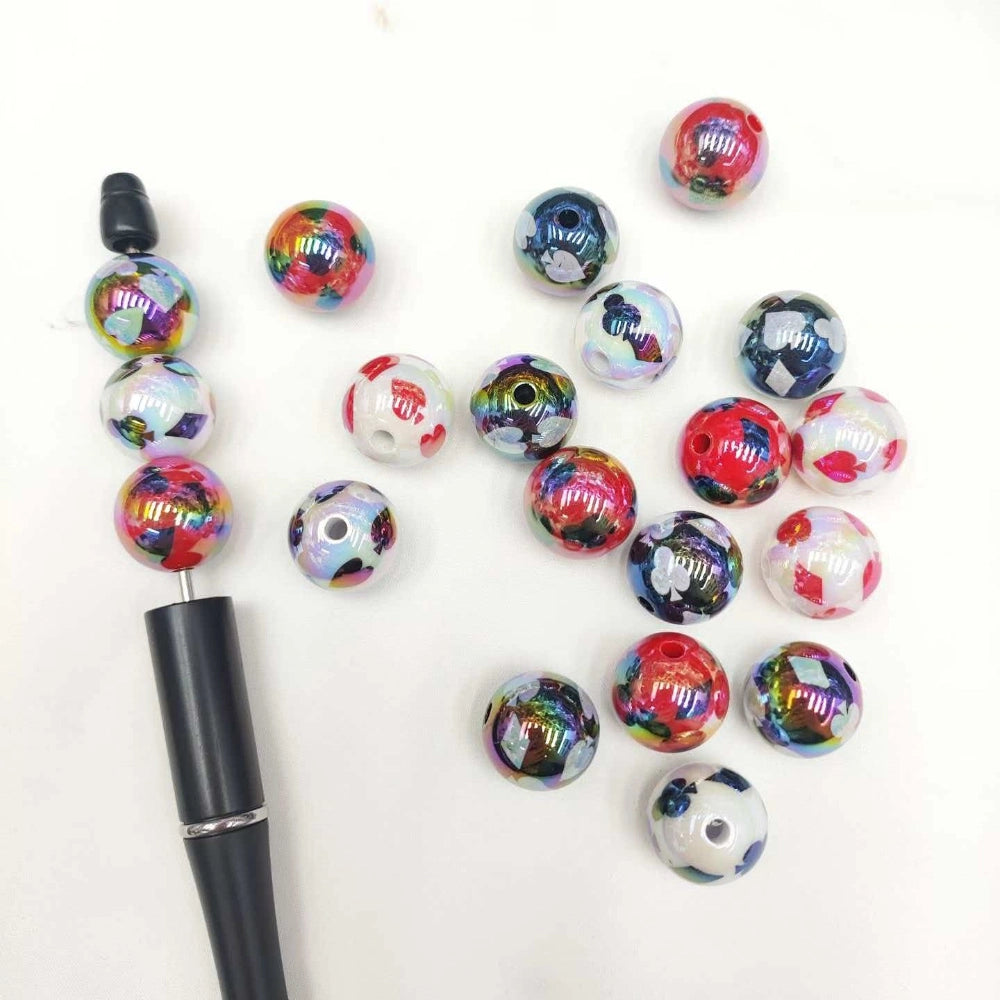Assorted 16MM round acrylic beads with iridescent card suit prints displayed beside a beadable pen