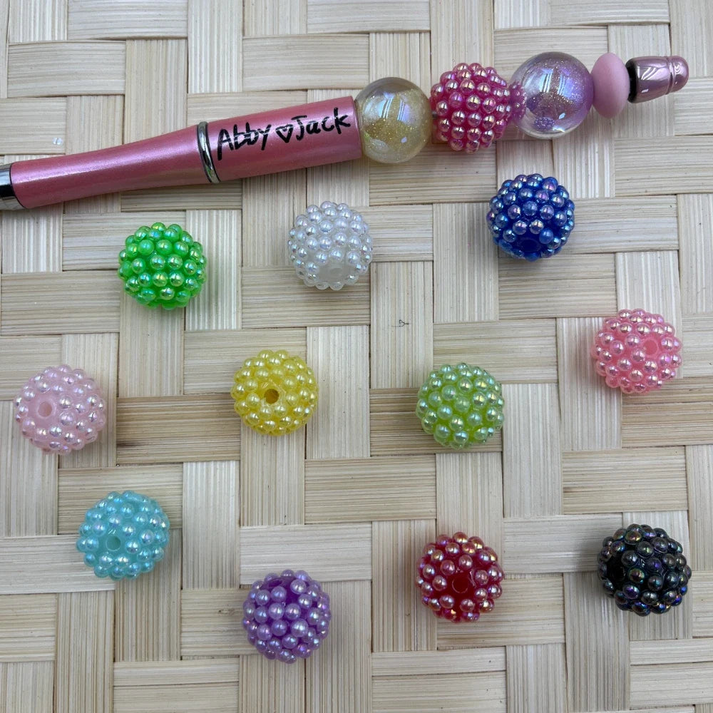 Assorted 16MM pearl bubble acrylic fancy beads with glossy raised pearl texture, shown beside a beadable pen in pastel and jewel tones.