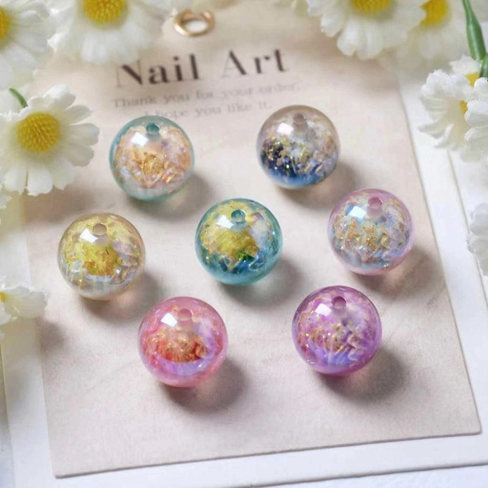 16MM round aurora acrylic beads with galaxy glitter and gold foil flakes in pastel teal, blue, yellow, green, pink, and purple colorways displayed on a nail art card with daisies.
