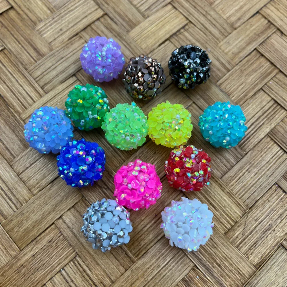 16MM rhinestone cluster ball beads in multiple colors including purple, green, neon yellow, teal, blue, hot pink, red, silver, white, black, and gunmetal displayed on a woven surface.