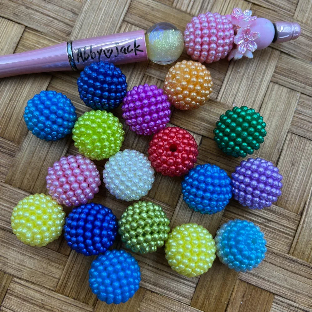 20MM colorful berry cluster acrylic beads in assorted colors including blue, pink, green, yellow, purple, red, orange, and white, displayed on a woven surface next to a beadable pen.
