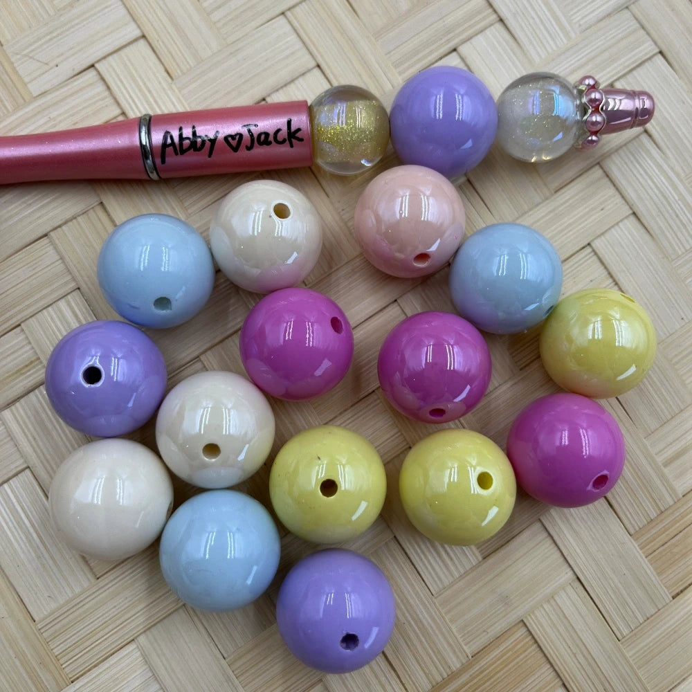 20MM pastel solid acrylic beads in assorted colors including lavender, pink, yellow, baby blue, and cream displayed on a wicker surface next to a beadable pen.