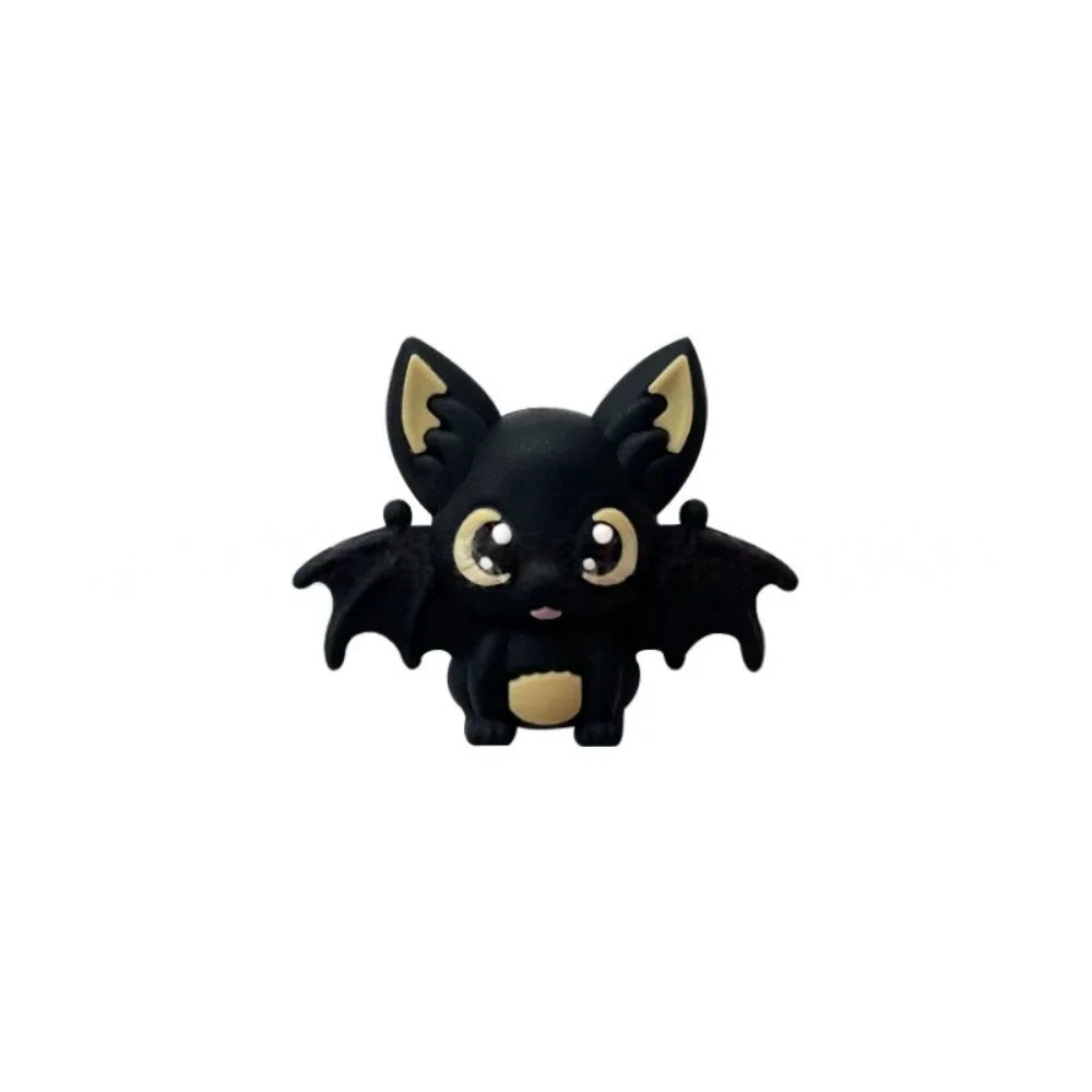 Six colorful 3D silicone baby bat focal beads in black, purple, gray, white, brown, and copper displayed on a wooden tray against a pink background. - Black