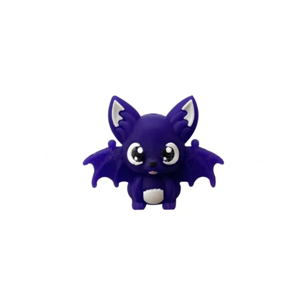 Six colorful 3D silicone baby bat focal beads in black, purple, gray, white, brown, and copper displayed on a wooden tray against a pink background. - Blue