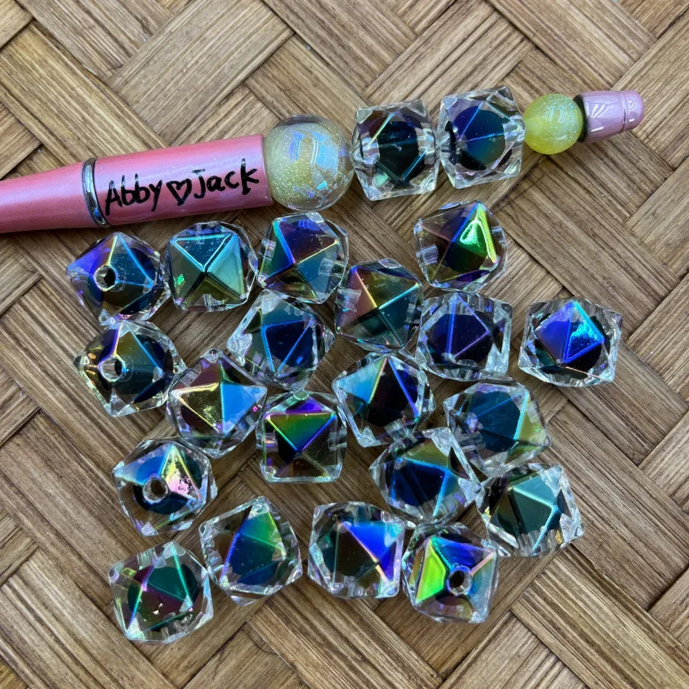 Loose 16MM clear iridescent faceted cube acrylic beads displayed beside a pink beadable pen