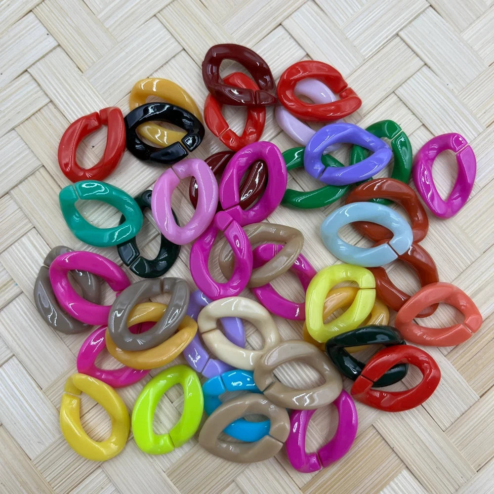 Assorted colorful glossy acrylic twist chain link ring fancy beads in multiple colors including pink, red, green, yellow, blue, and more, displayed on a woven rattan surface.