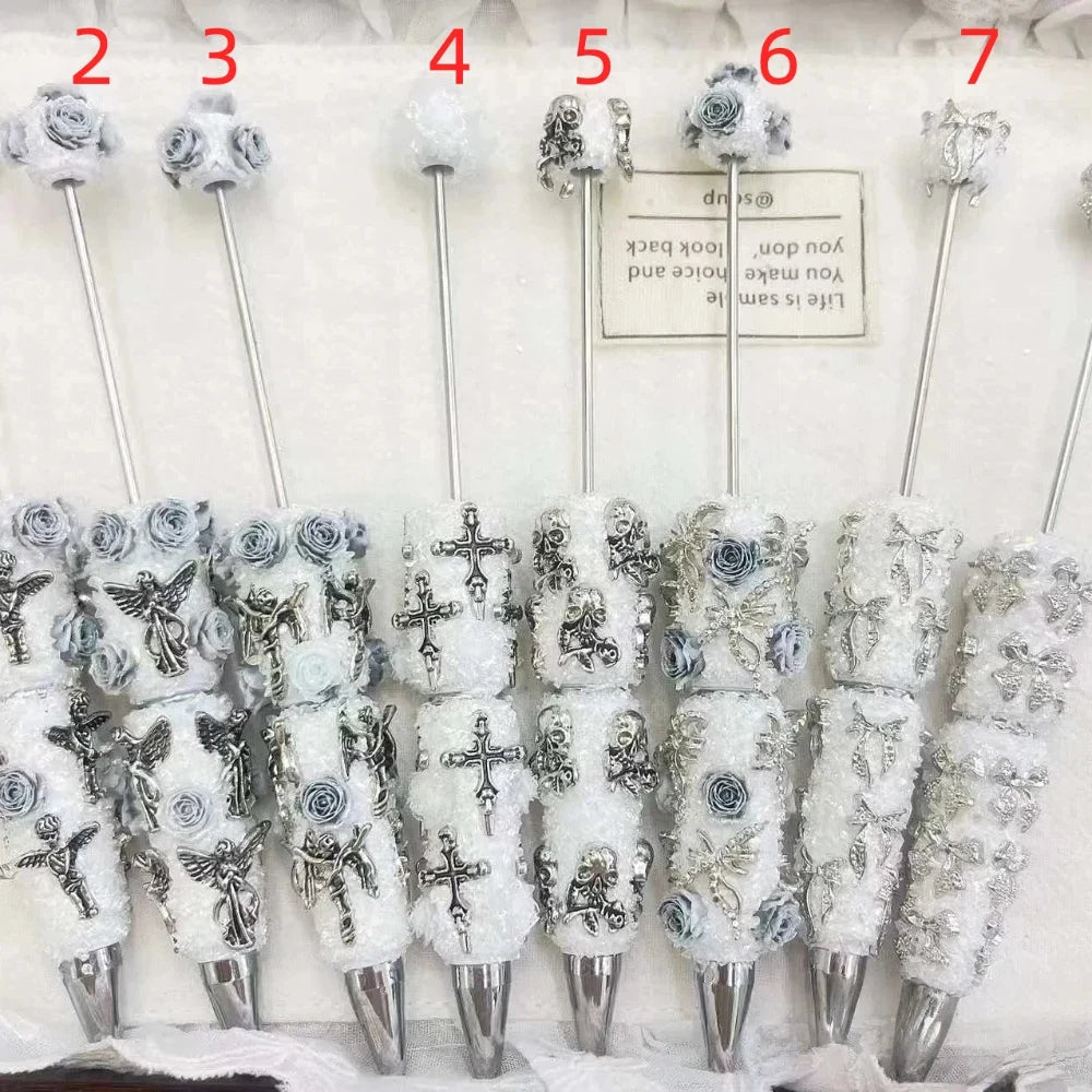 Assorted white and silver floral charm rhinestone pens with rose, cross, angel, skull, bow, and butterfly inspired accents