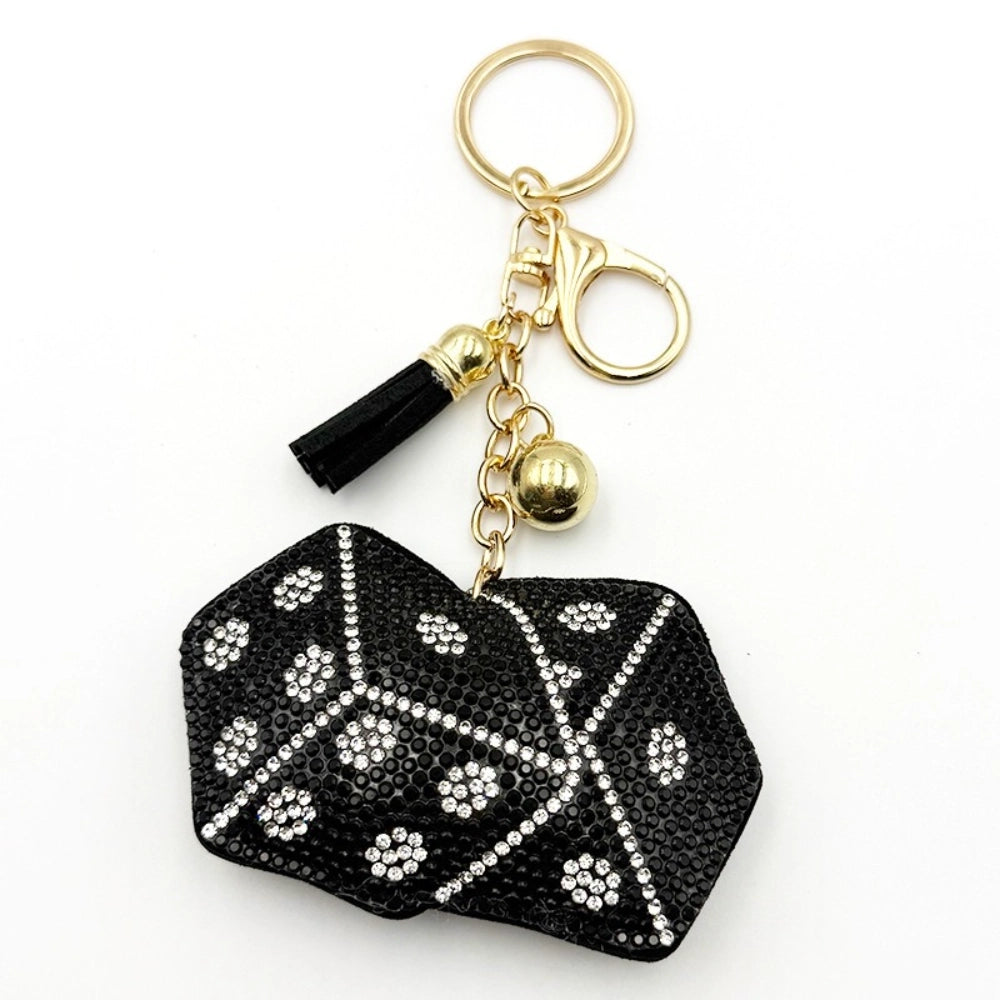 Black and clear crystal rhinestone lips shaped keychain charm with gold lobster clasp, chain, gold ball bead, and black tassel on white background.