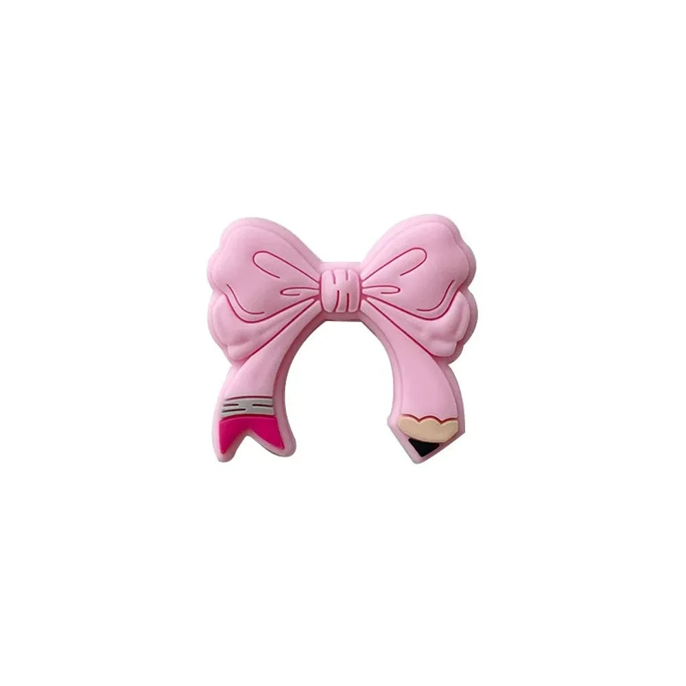 Assorted colorful bow tie silicone focal beads in light pink, hot pink, teal, yellow, and magenta displayed on a miniature white bench with pink background - Light Pink