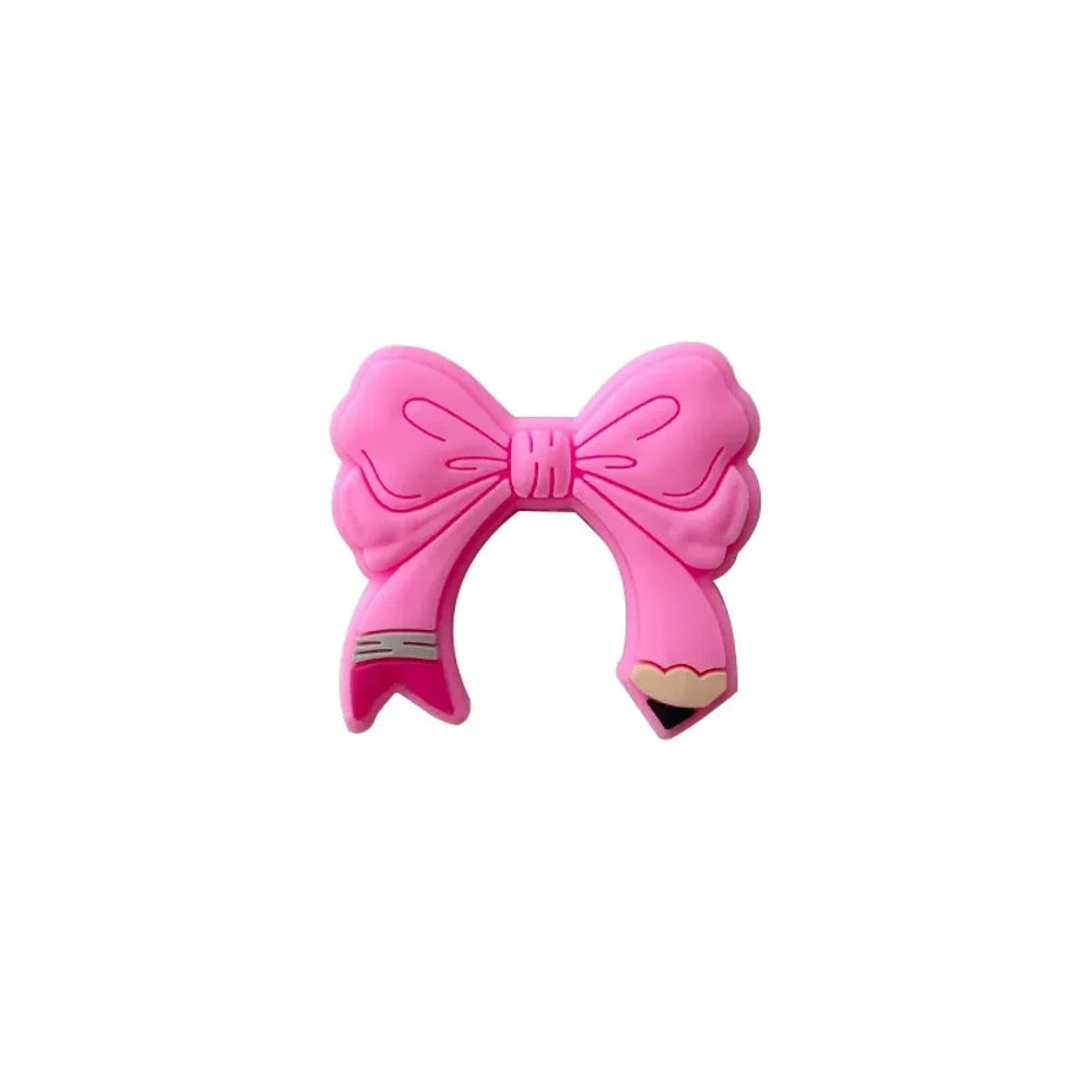 Assorted colorful bow tie silicone focal beads in light pink, hot pink, teal, yellow, and magenta displayed on a miniature white bench with pink background - Pink