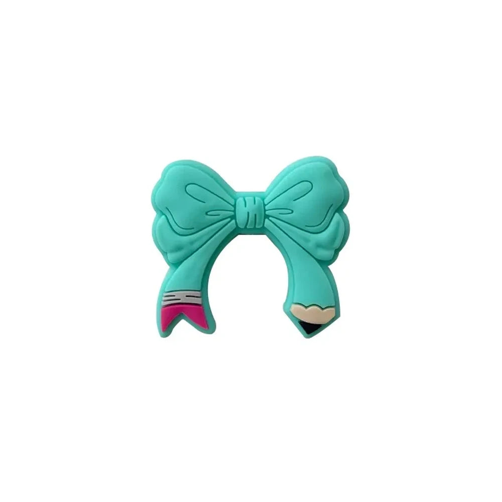 Assorted colorful bow tie silicone focal beads in light pink, hot pink, teal, yellow, and magenta displayed on a miniature white bench with pink background - Turquoise