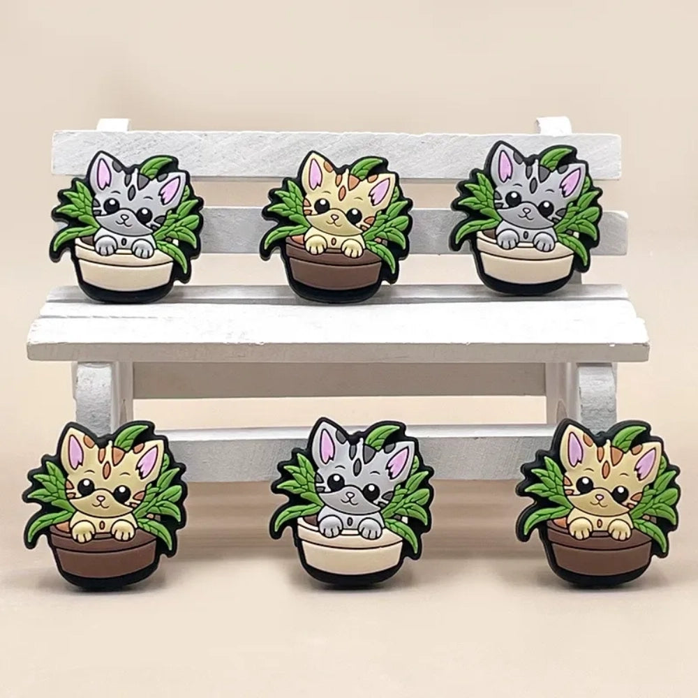 Six kawaii cat in flower pot silicone focal beads in gray and tan colorways with green plant leaves, displayed on a miniature white wooden bench — perfect for beadable pens, keychains, and badge reels. - Random Mixed