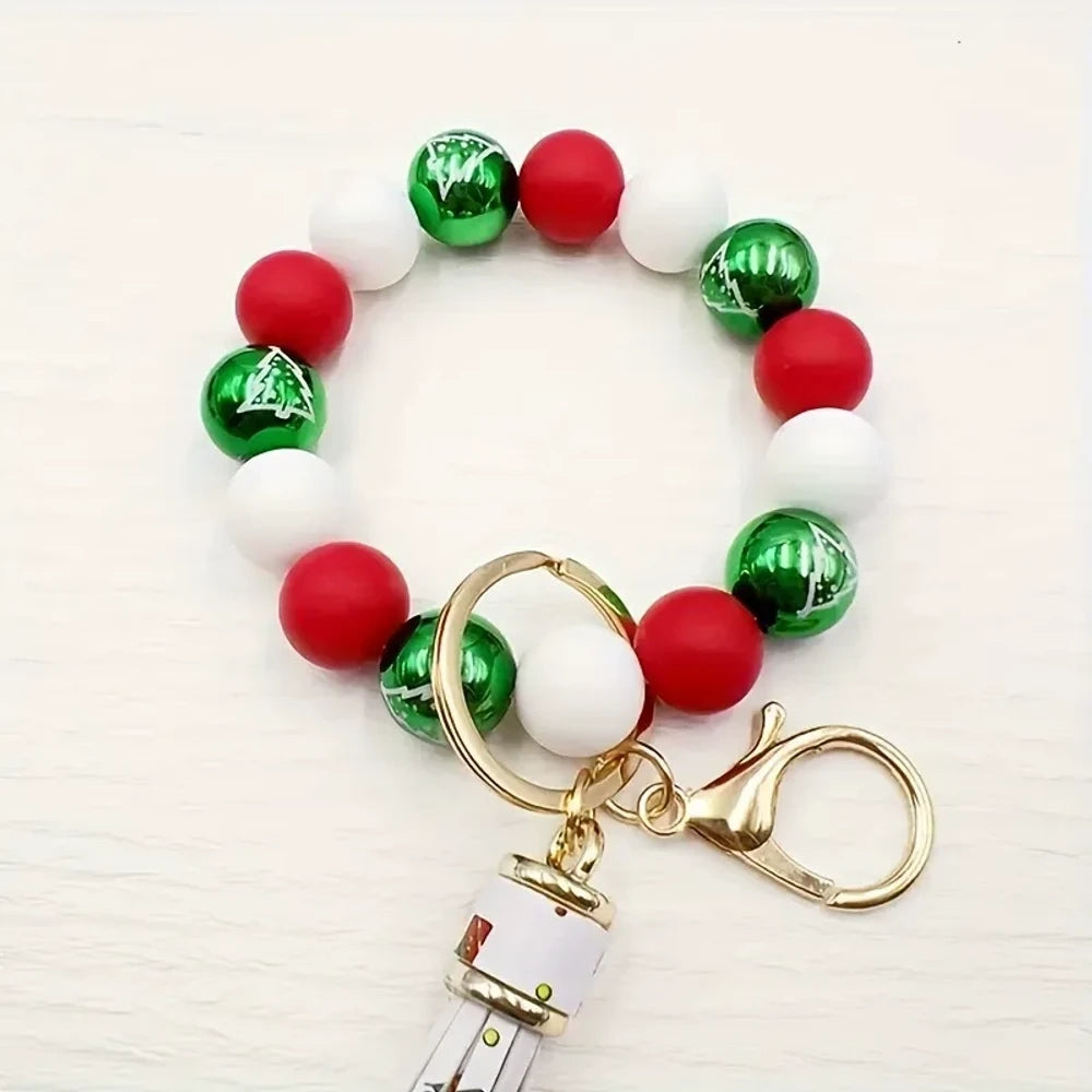 Christmas holiday printed silicone beads in red, green, and white with snowflake and Santa patterns, shown on beaded bracelet keychain wristlets with tassels. - 1