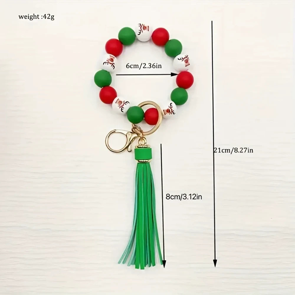Christmas holiday printed silicone beads in red, green, and white with snowflake and Santa patterns, shown on beaded bracelet keychain wristlets with tassels. - 2