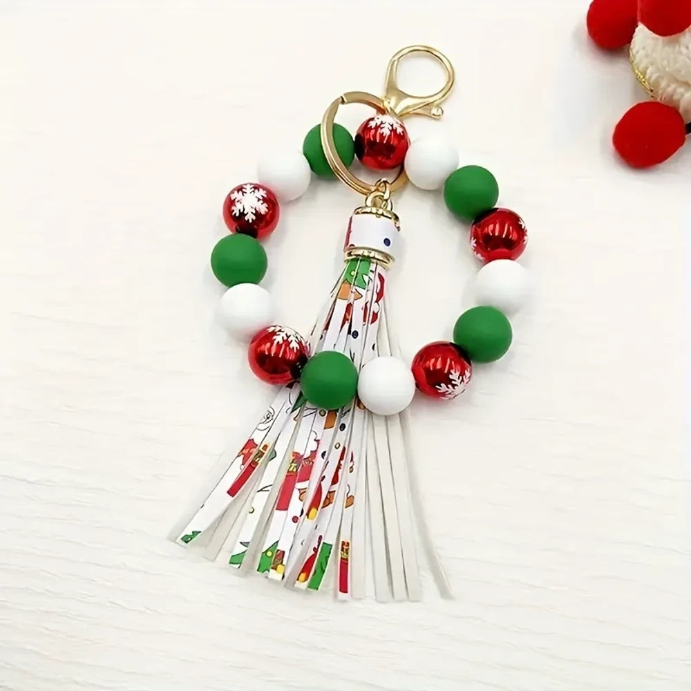 Christmas holiday printed silicone beads in red, green, and white with snowflake and Santa patterns, shown on beaded bracelet keychain wristlets with tassels. - 4