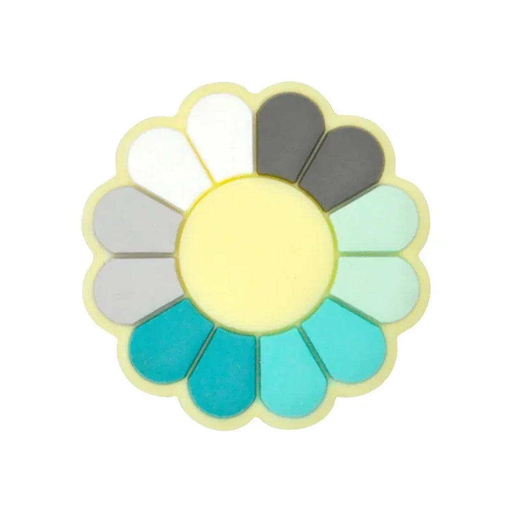 Five color wheel flower silicone focal beads arranged in a circle, each featuring a yellow center with multicolored petals in cool blues, teals, warm reds, pastels, and rainbow combinations on a light gray background. - Green