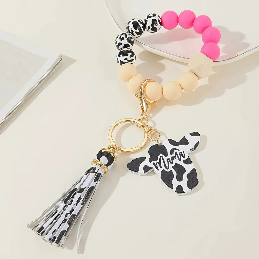 Cow print black and white silicone beads mixed with solid color silicone beads on bracelet keychains with mama butterfly charm and tassel pendants in pink, black, teal, and purple color combinations - Rose Red