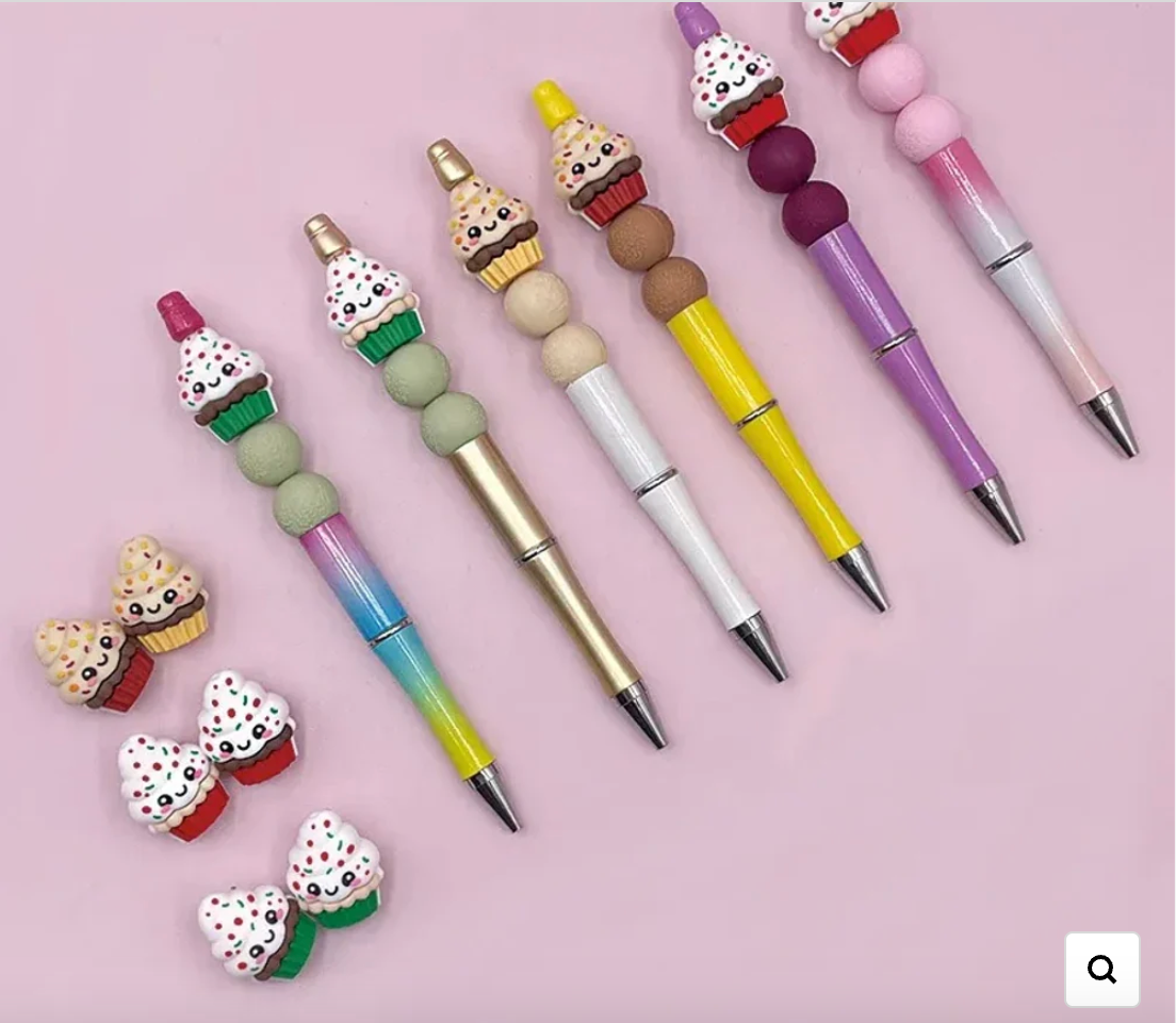 Kawaii cupcake 3D silicone focal beads with sprinkles and smiley faces displayed on colorful beadable pens against a pink background, available at DIY Mini Planet. - Random Mixed