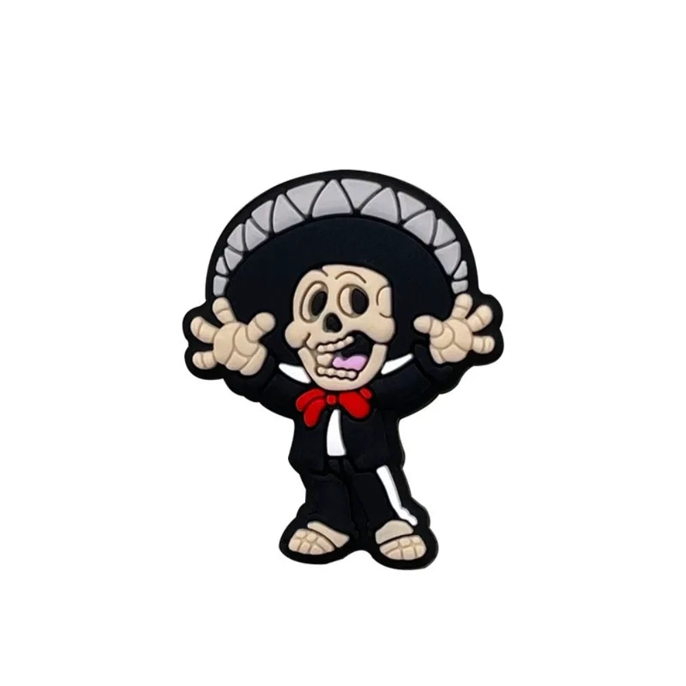 Four Day of the Dead skeleton silicone focal beads in black, gray, red, and gold colorways featuring Catrina and Mariachi skeleton characters, displayed in a clear acrylic pen holder. - Boy