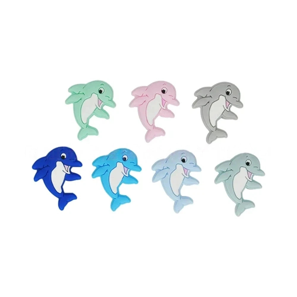 Seven colorful silicone dolphin focal beads in mint, pink, gray, navy, teal, light blue, and sage green with white belly detail, smiling cartoon style, for DIY jewelry and beadable crafts. - Random Mixed