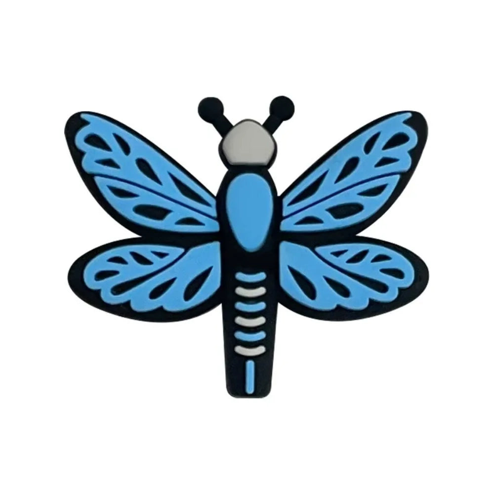Seven colorful dragonfly silicone focal beads in pink, hot pink, and blue shades arranged on a pink background, featuring detailed wing patterns and black outlines. - Blue