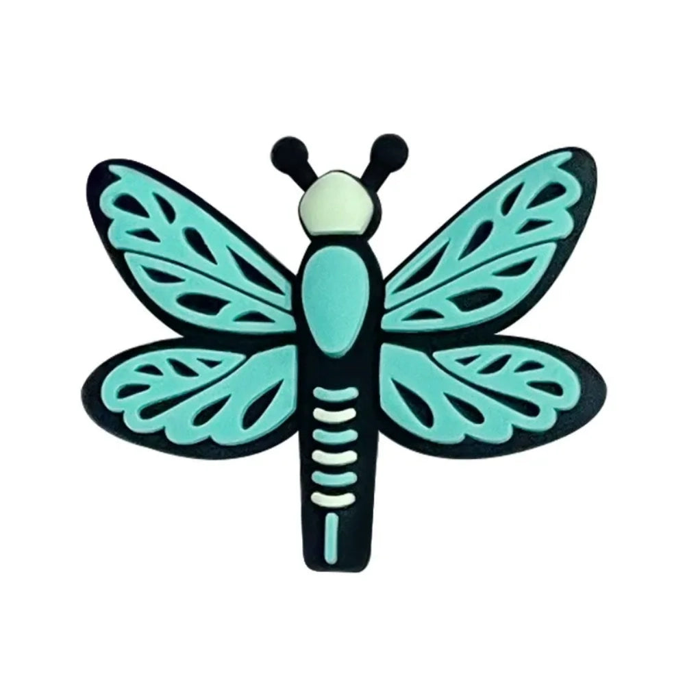 Seven colorful dragonfly silicone focal beads in pink, hot pink, and blue shades arranged on a pink background, featuring detailed wing patterns and black outlines. - Green