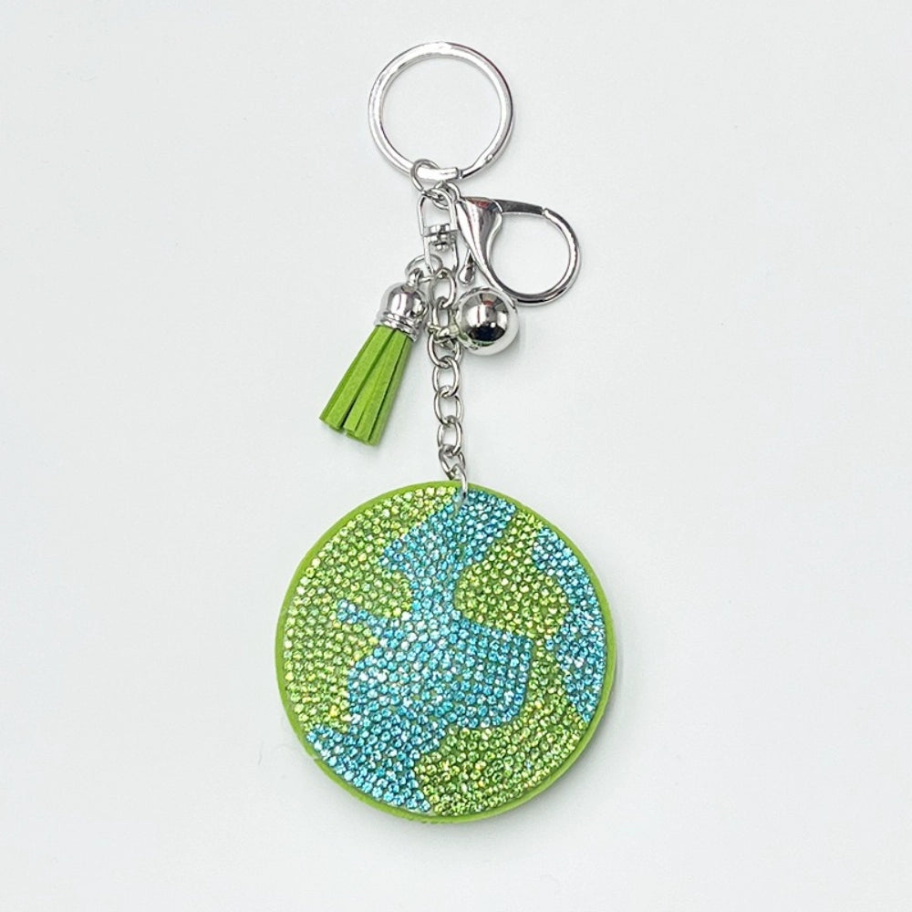 Round earth globe rhinestone keychain charm with green and blue crystals, silver hardware, green tassel, and lobster clasp on white background.