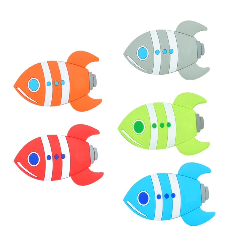 Five colorful fish rocket silicone focal beads in orange, red, green, blue, and gray with white stripe details and blue eye accents, shown on white background.