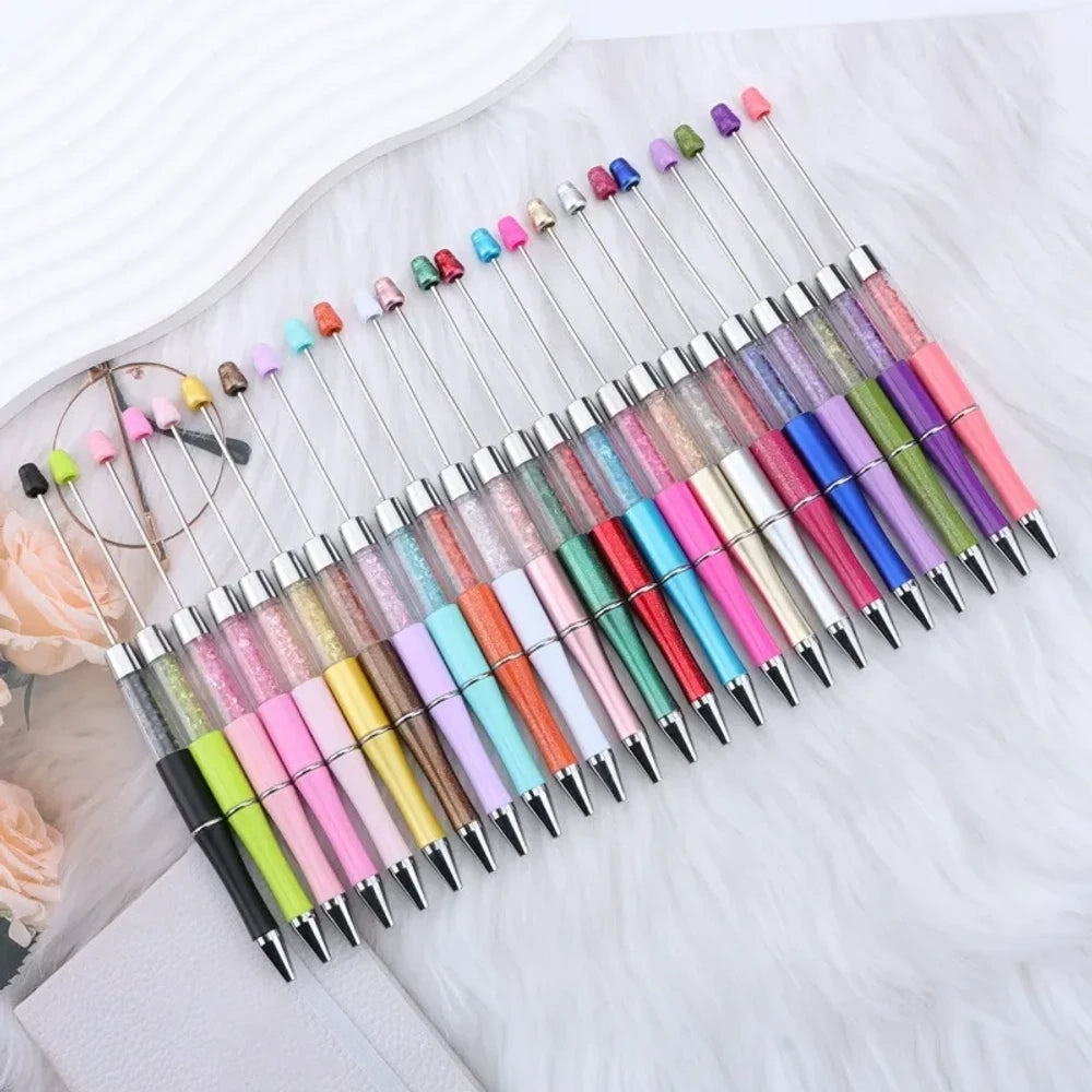 25-piece set of multicolor glitter crystal beadable plastic pens with silver accents and bead bar tops, arranged in a fan display on white fabric