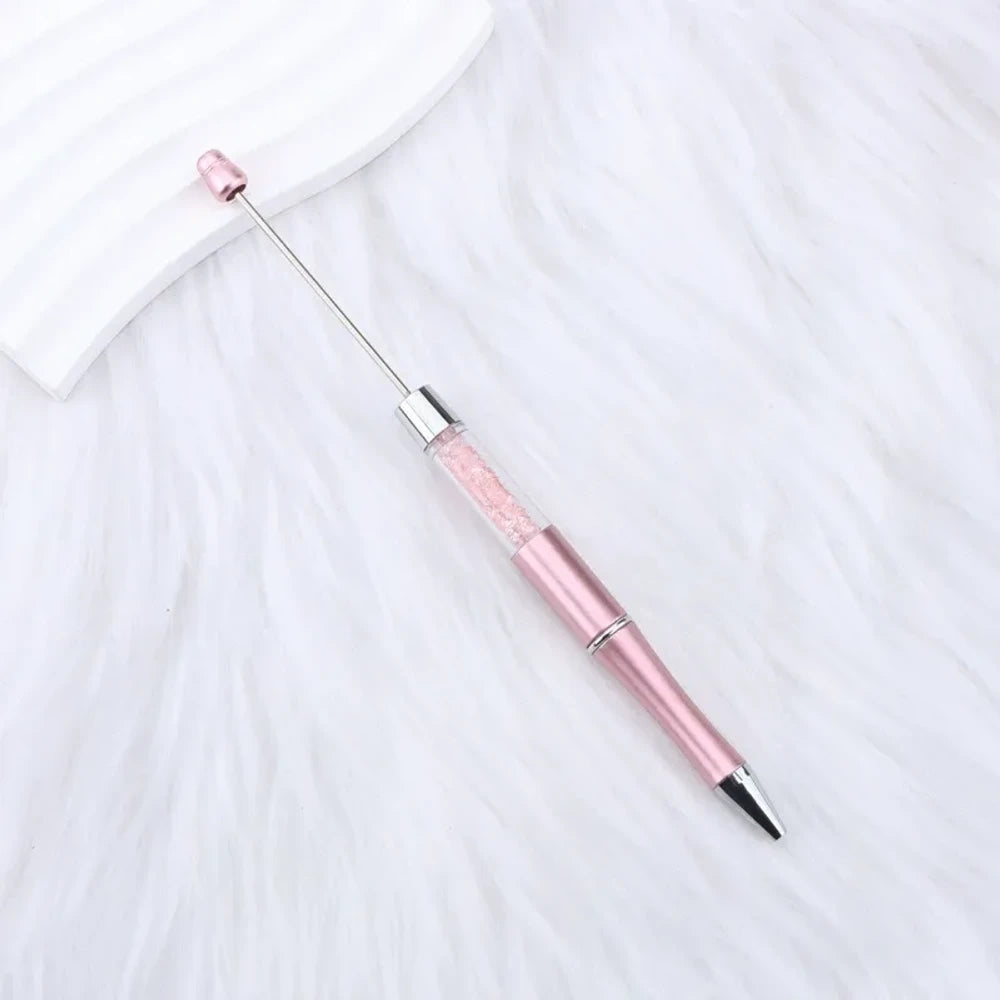25-piece set of multicolor glitter crystal beadable plastic pens with silver accents and bead bar tops, arranged in a fan display on white fabric - 20