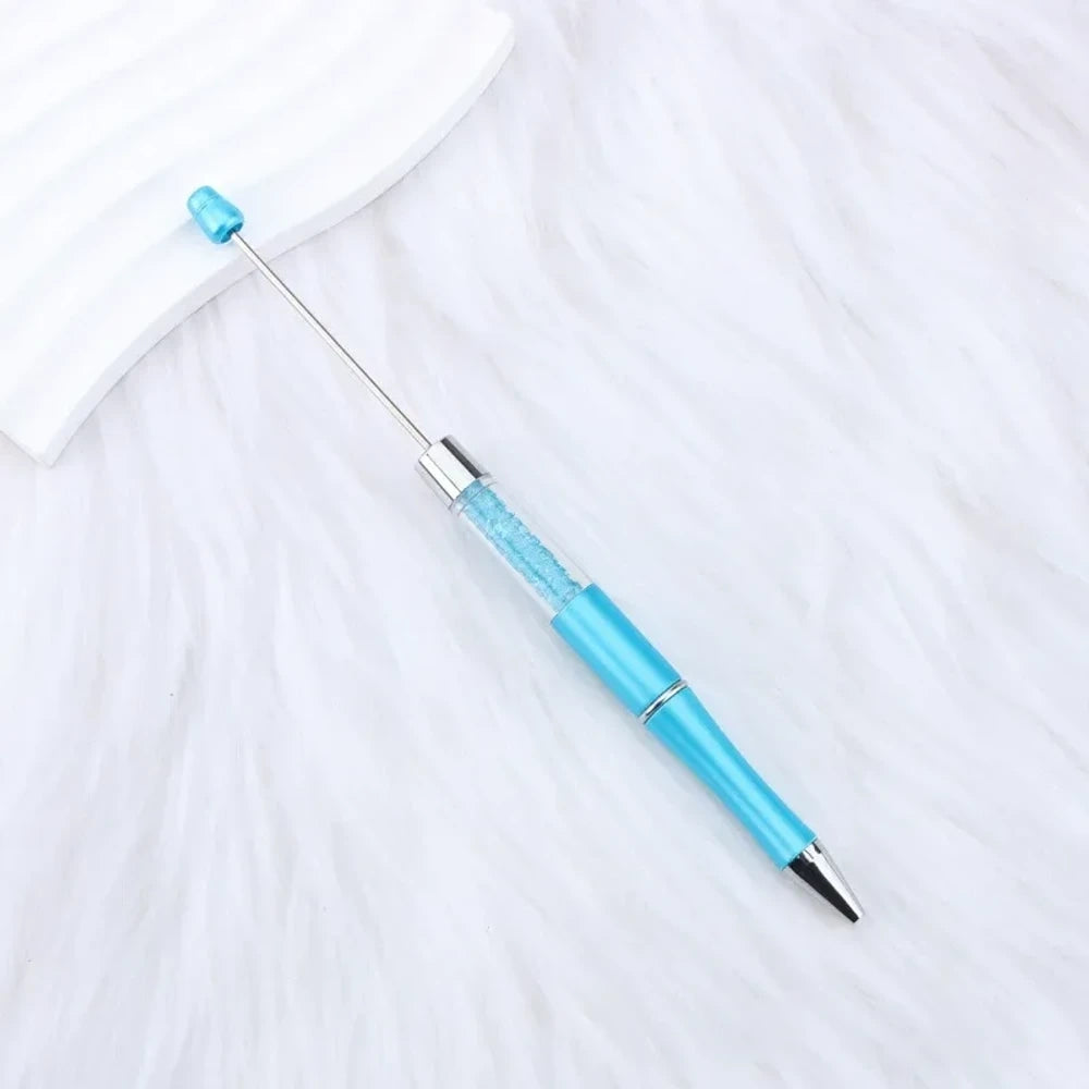 25-piece set of multicolor glitter crystal beadable plastic pens with silver accents and bead bar tops, arranged in a fan display on white fabric - 5