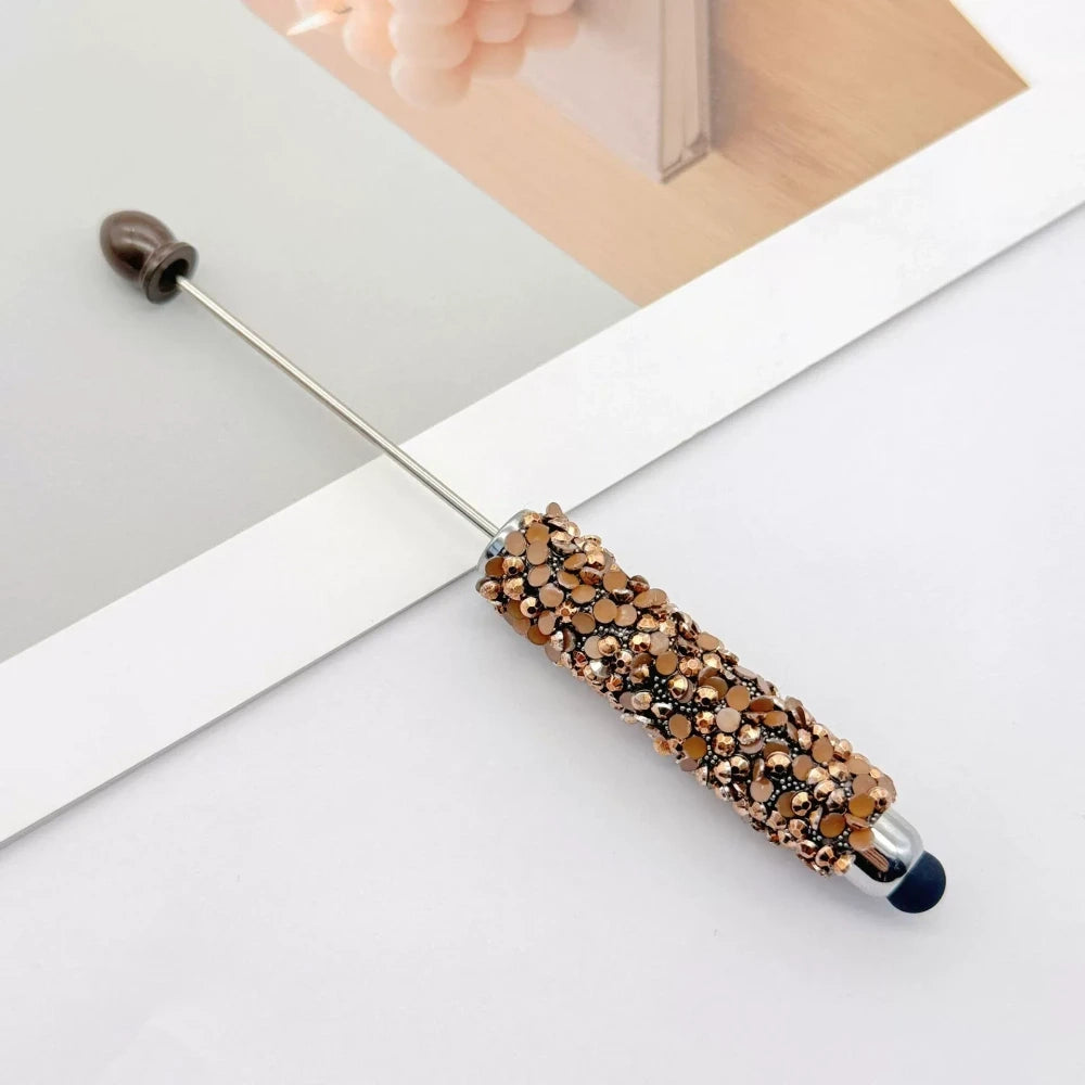 Set of 11 glitter rhinestone beadable pens in assorted colors including white, hot pink, black, multicolor, pink, light pink, teal, brown, purple, blue, and lavender, displayed on a white surface. - 10