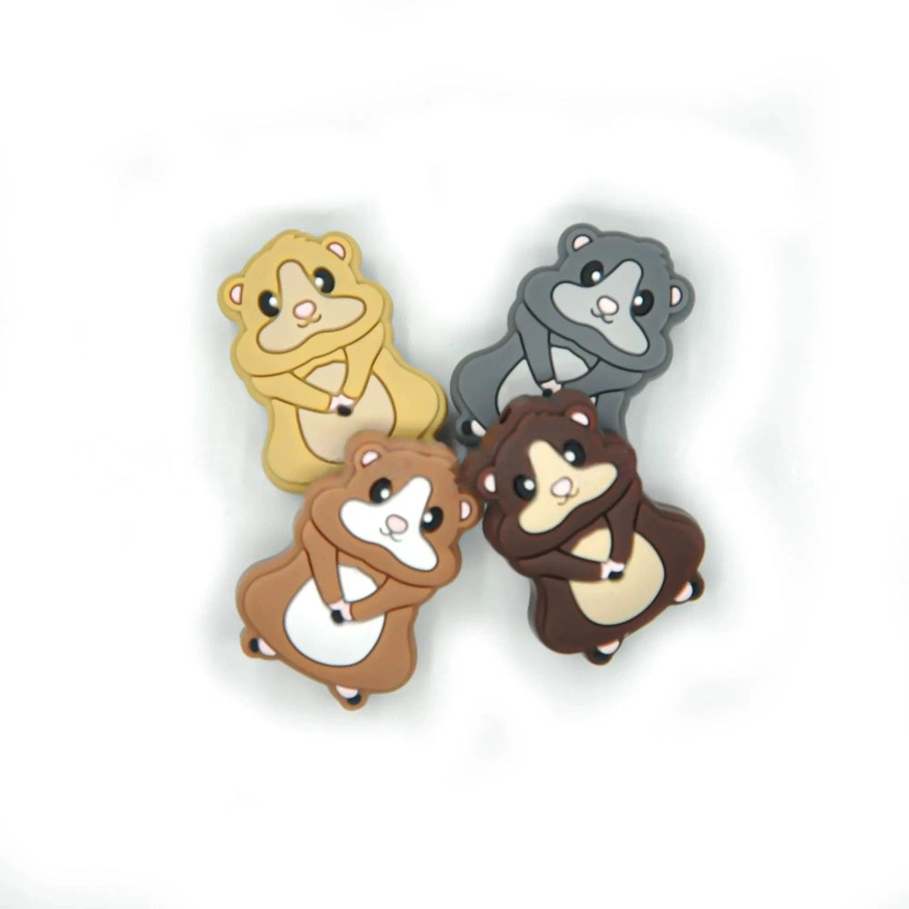Four cute cartoon hamster silicone focal beads in yellow, gray, brown, and dark brown colorways, shown from front view on white background.