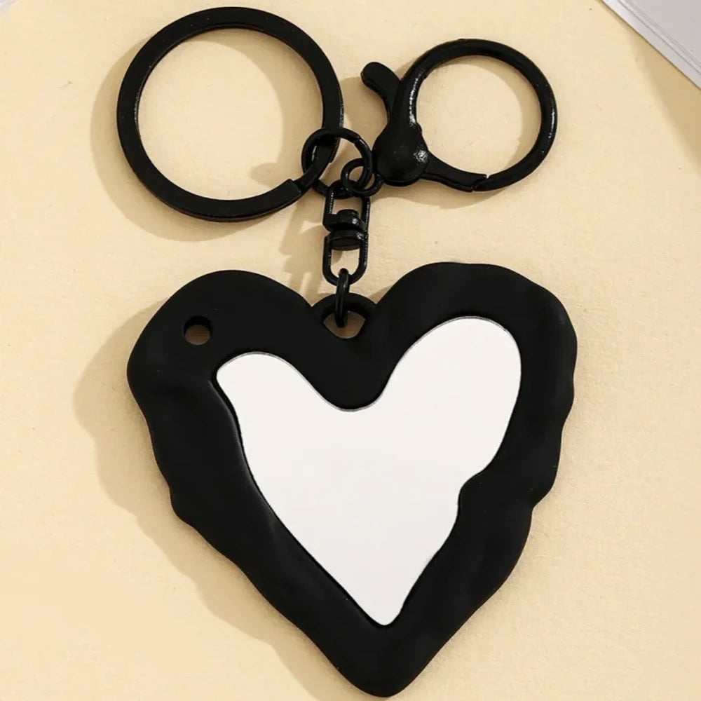 Nine colorful heart-shaped photo frame keychain pendants in purple, pink, hot pink, red, white, black, brown, yellow, and blue with lobster clasp rings on a beige surface. - 4